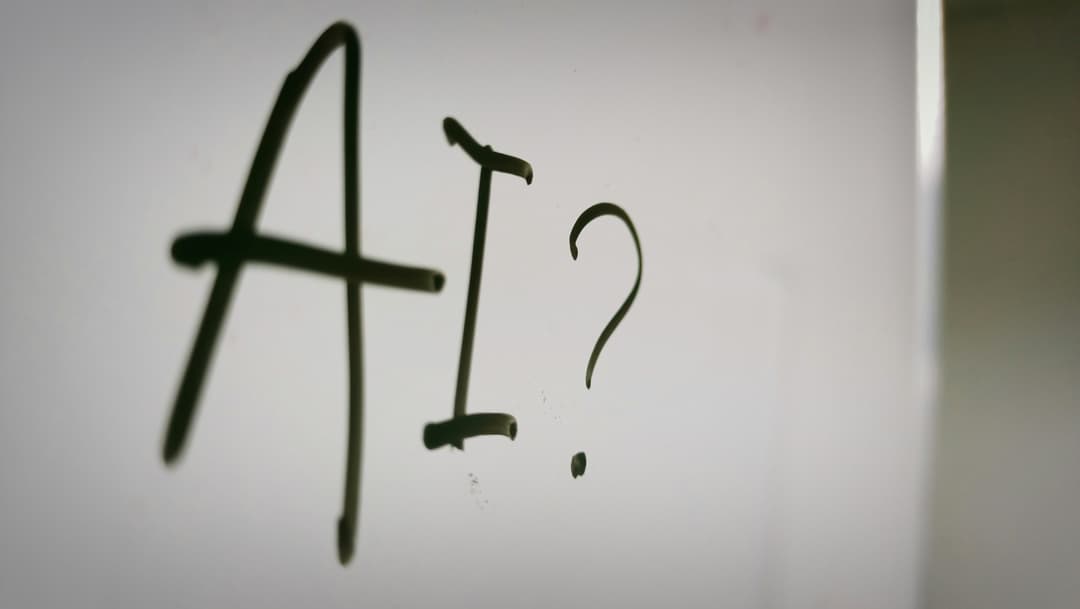 The letters A I and a question mark drawn on a whiteboard