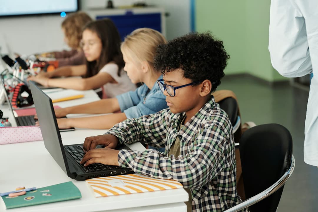 Students working on laptops in a classroom
